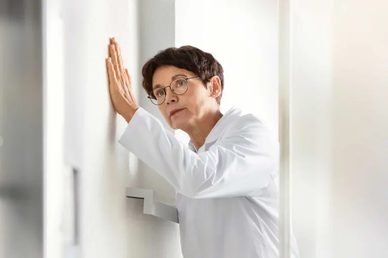 Laboratory photo of a Sto colleague holding her hand to the sustainable facade system StoThermAimS®.