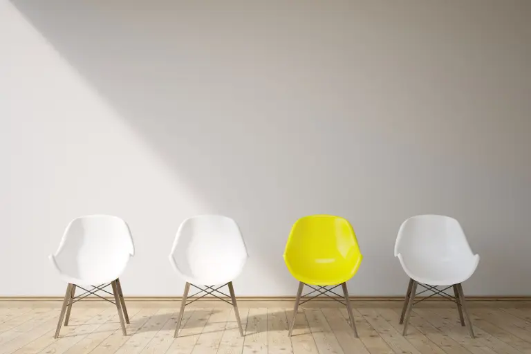 Open positions Sto: three white chairs, one yellow, job offers, free seat; 