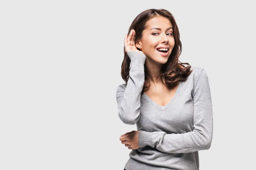Woman holds a hand to her ear to hear better;  acoustics;  well-being