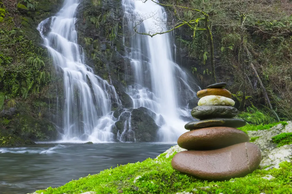 Rock Zen pyramid, stone pyramid in front of waterfall, environmental protection