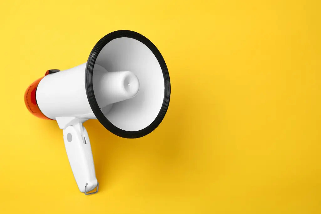 White megaphone on a yellow background, actively communicating climate protection