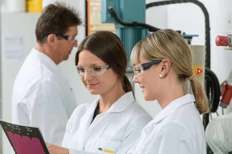 Two Sto colleagues from Research & Development look at a laboratory report, in the background another R&D employee;
